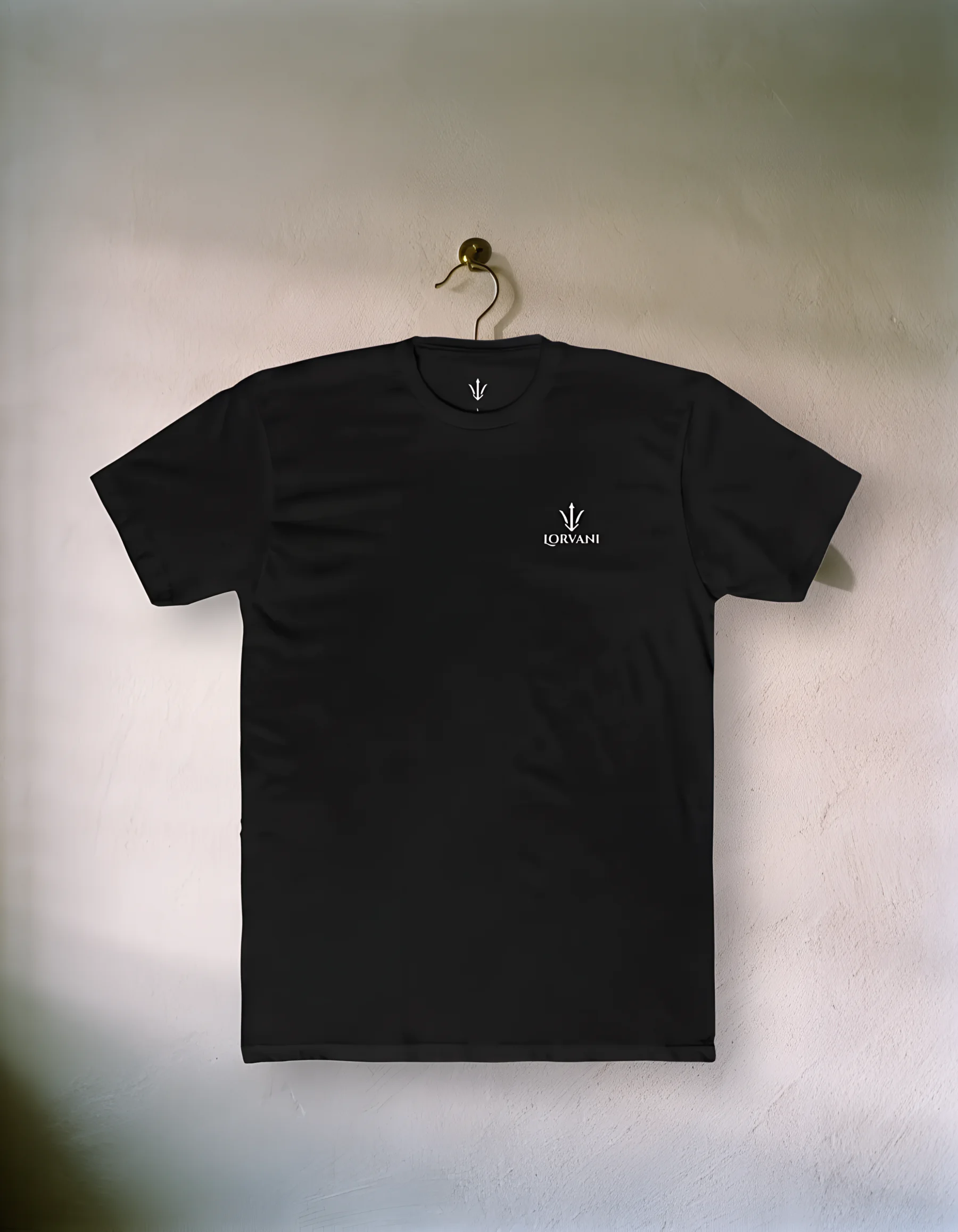 The black tee on a hanger against a plaster wall