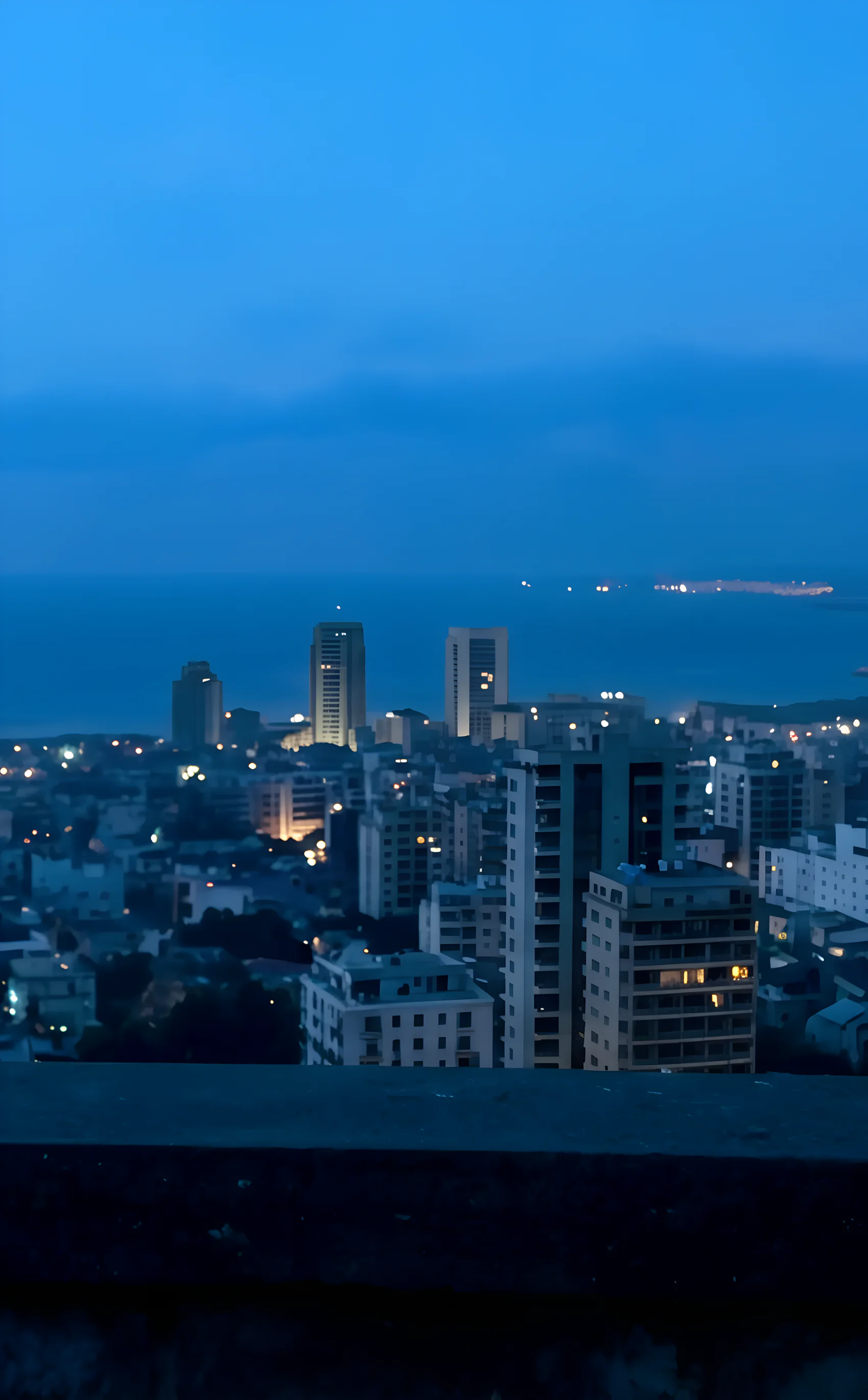 Beirut at blue hour, seen from a balcony above the city and the sea